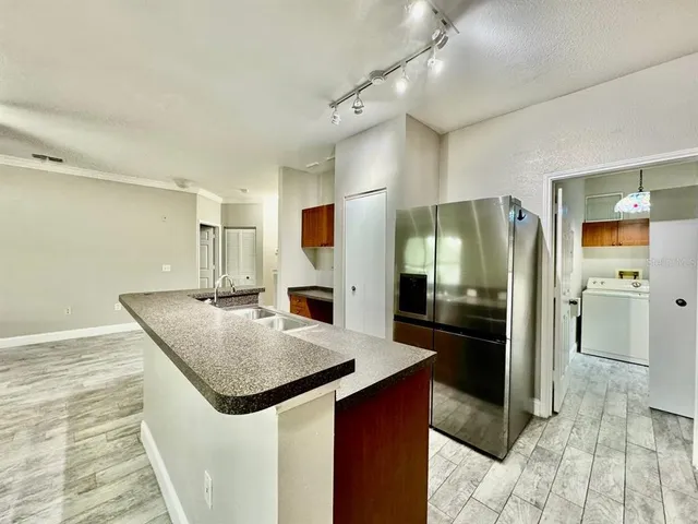 a kitchen with stainless steel appliances granite countertop a sink and a refrigerator
