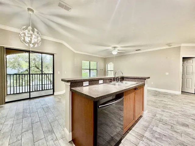 a kitchen with a stove a sink and a large window