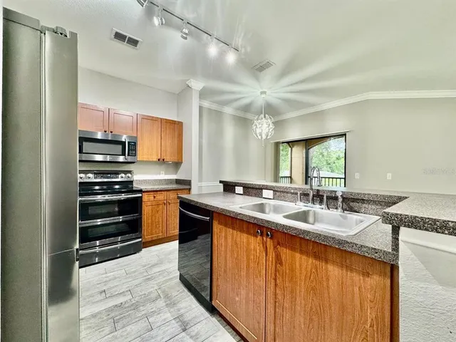 a kitchen with stainless steel appliances granite countertop a stove a sink and a refrigerator