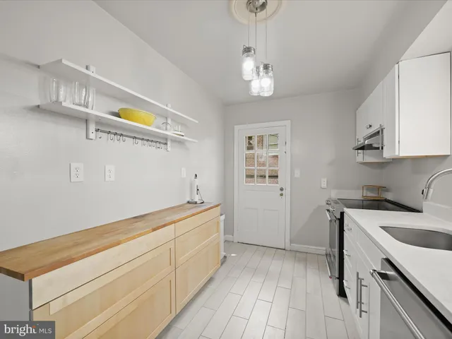 a room with a sink cabinets and wooden floor