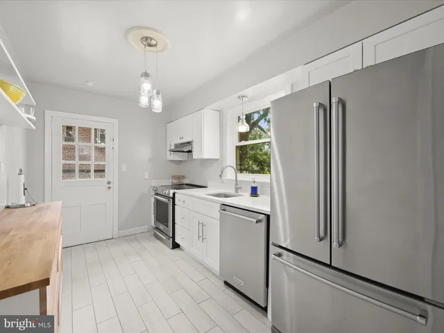 a kitchen with stainless steel appliances a refrigerator and a stove top oven