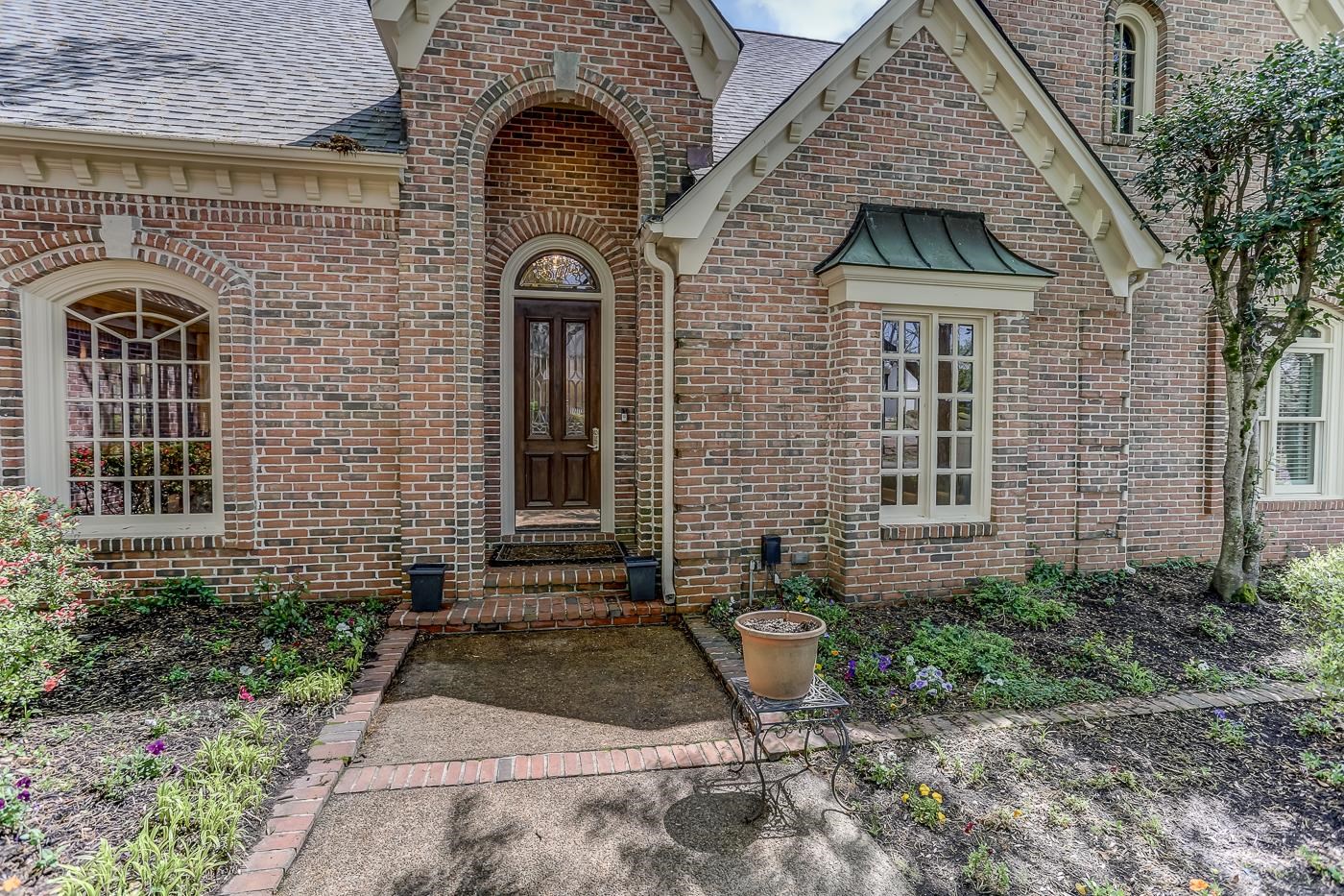 8711 Windrush Memphis, TN 38125 - Photo 2 of 40 a front view of a house with garden