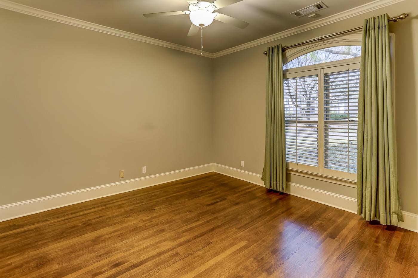 8711 Windrush Memphis, TN 38125 - Photo 27 of 40 a view of an empty room with wooden floor and a window