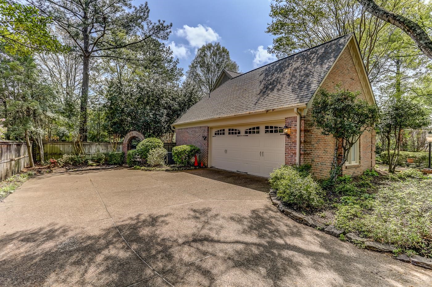 8711 Windrush Memphis, TN 38125 - Photo 3 of 40 a front view of a house with a yard and garage