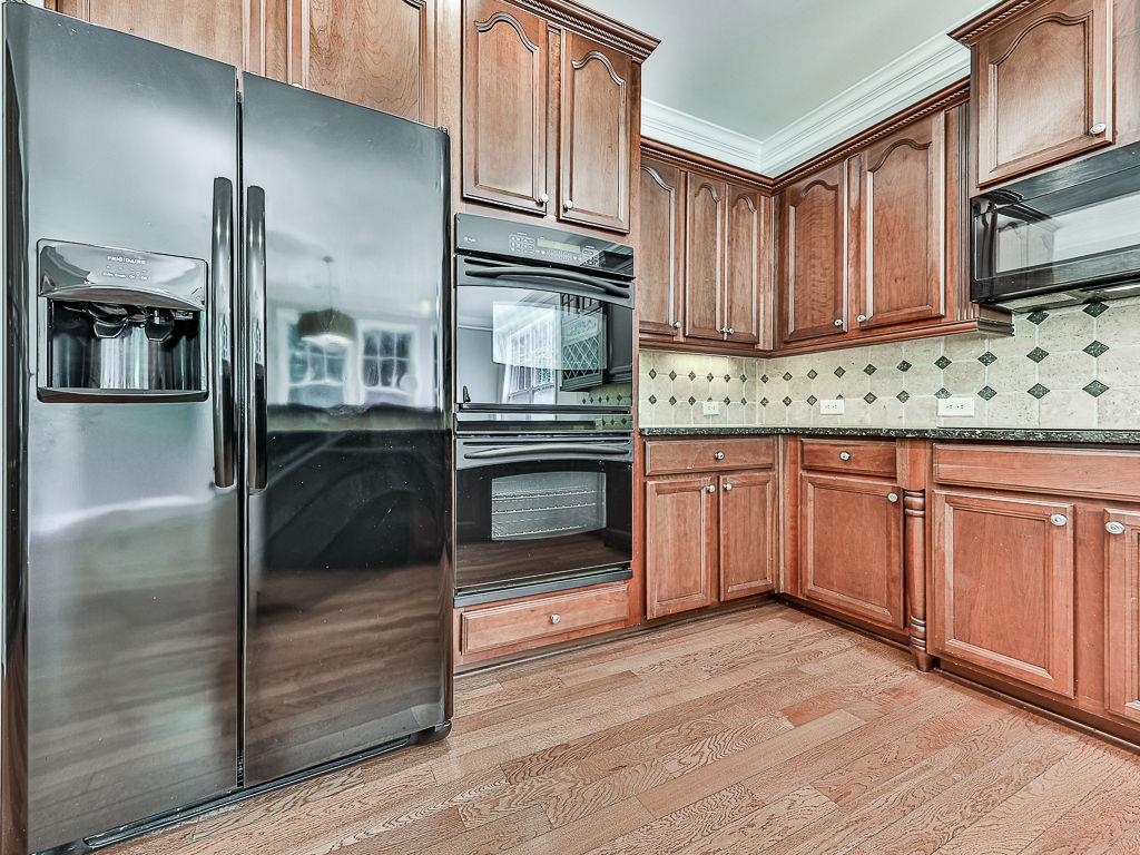 626 Laurel Crossing Canton, GA 30114 - Photo 22 of 77 a kitchen with granite countertop wooden cabinets stainless steel appliances and a sink