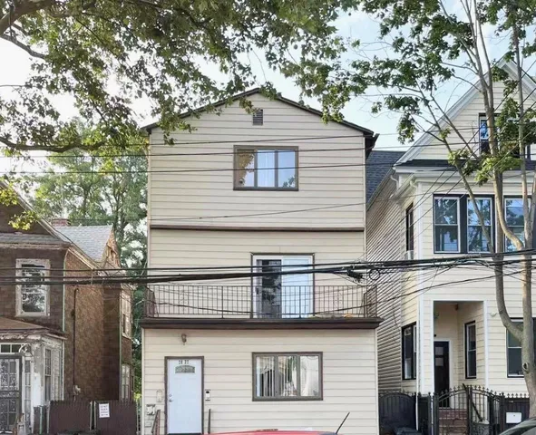 a front view of a house with a tree