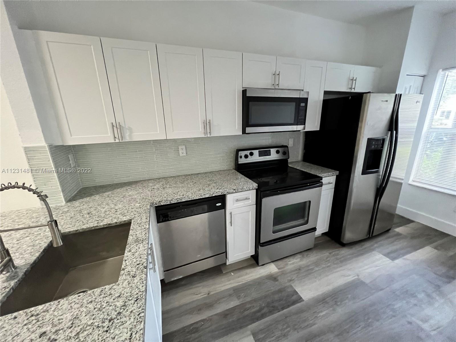 Vizcaya Miramar, FL 33027 - Photo 15 of 15 a kitchen with granite countertop stainless steel appliances a stove microwave and sink