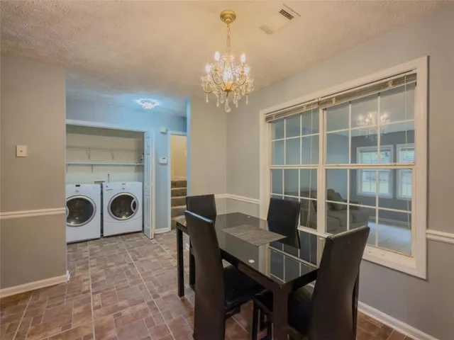 a view of a dining room with furniture a chandelier and wooden floor