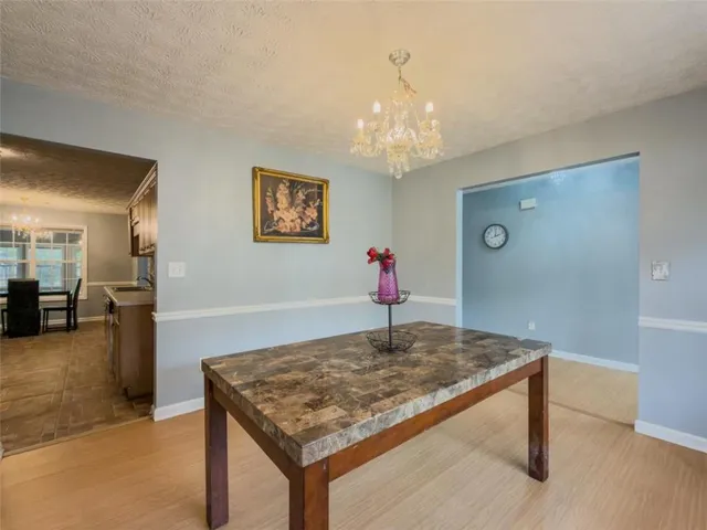 a hallway with window wooden floor and chandelier