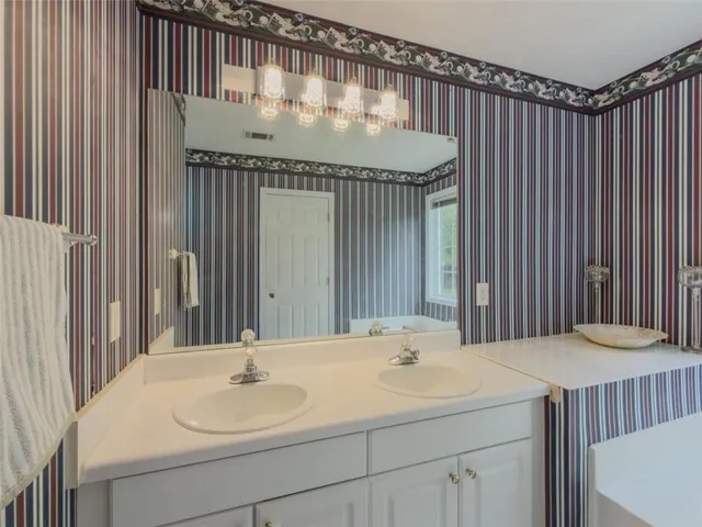 a bathroom with a tub sink and mirror