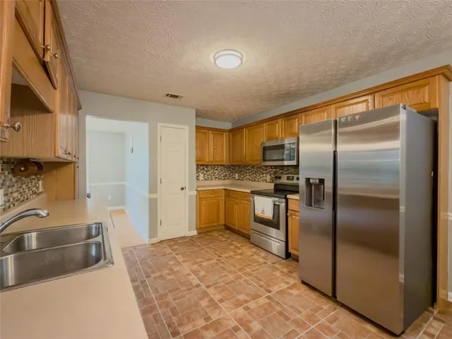 a kitchen with a refrigerator sink and cabinets