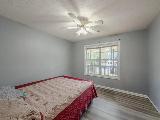 a bedroom with a bed and a chandelier fan