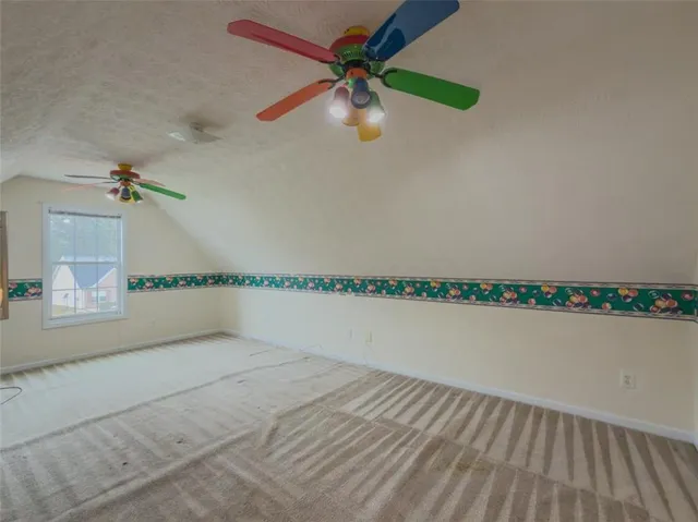 a view of a room with a ceiling fan and window