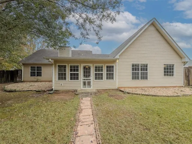 a front view of a house with a garden and trees