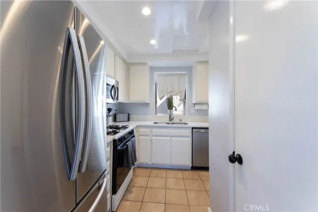 a kitchen with kitchen island a sink stove and refrigerator
