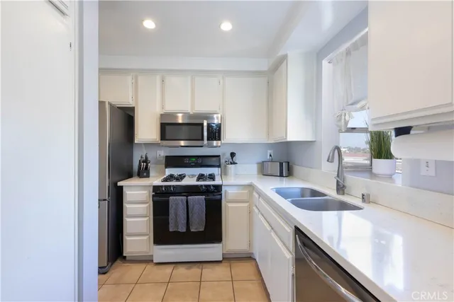a kitchen with stainless steel appliances granite countertop a sink stove microwave and refrigerator