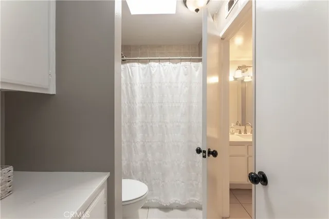a bathroom with a granite countertop sink a toilet and shower