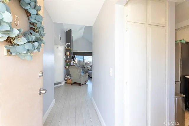 a view of a hallway with wooden floor and a bathroom