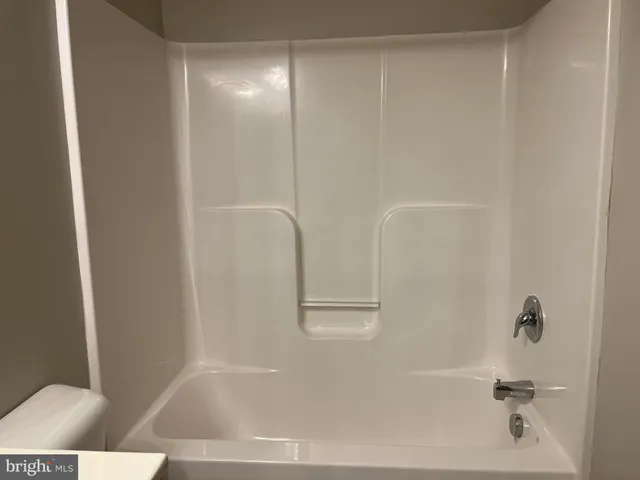 a view of a hallway with wooden floor and stairs