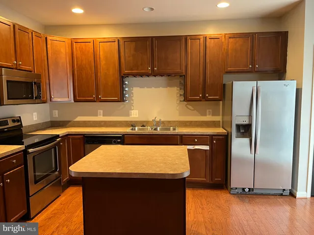 a kitchen with kitchen island a sink appliances and cabinets