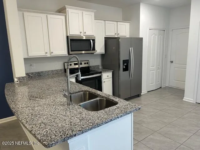 a kitchen with white cabinets stainless steel appliances and sink