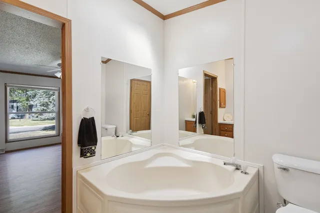 a bathroom with a tub sink and mirror