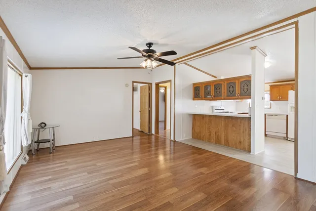a view of an empty room with a window and wooden floor