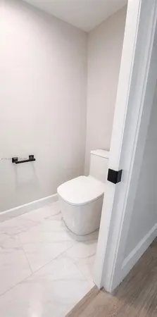 a white toilet sitting next to a shower