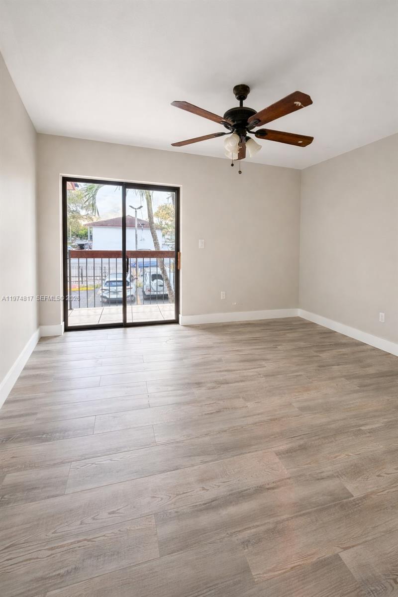 5935 West 16th Lane Hialeah, FL 33012 - Photo 3 of 15 wooden floor in an empty room with a window