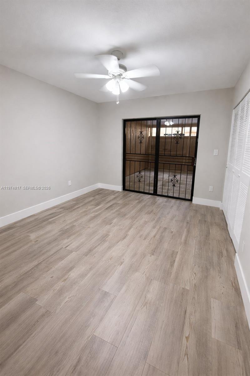 5935 West 16th Lane Hialeah, FL 33012 - Photo 5 of 15 an empty room with wooden floor and windows