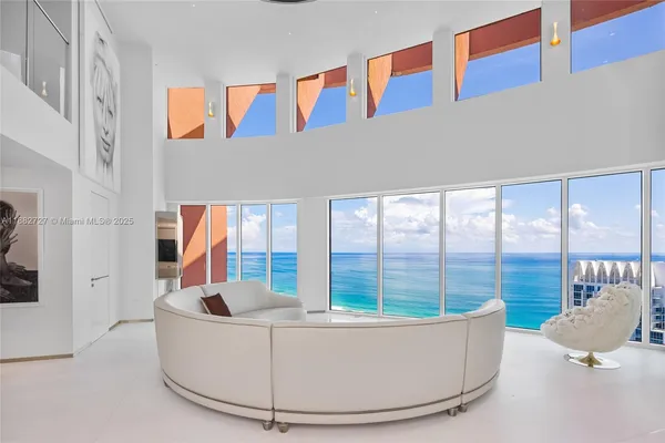 a living room with furniture and large windows