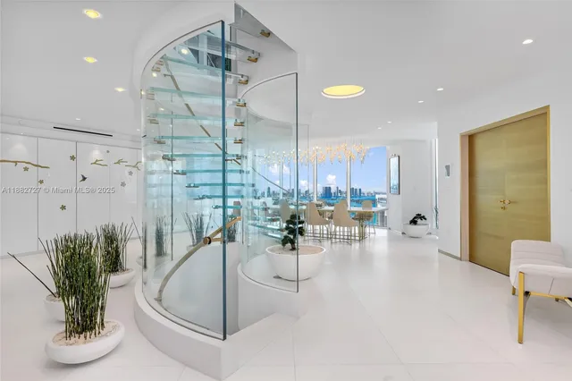 a living room with couches and potted plants with wooden floor