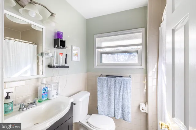 a bathroom with a sink toilet vanity and window