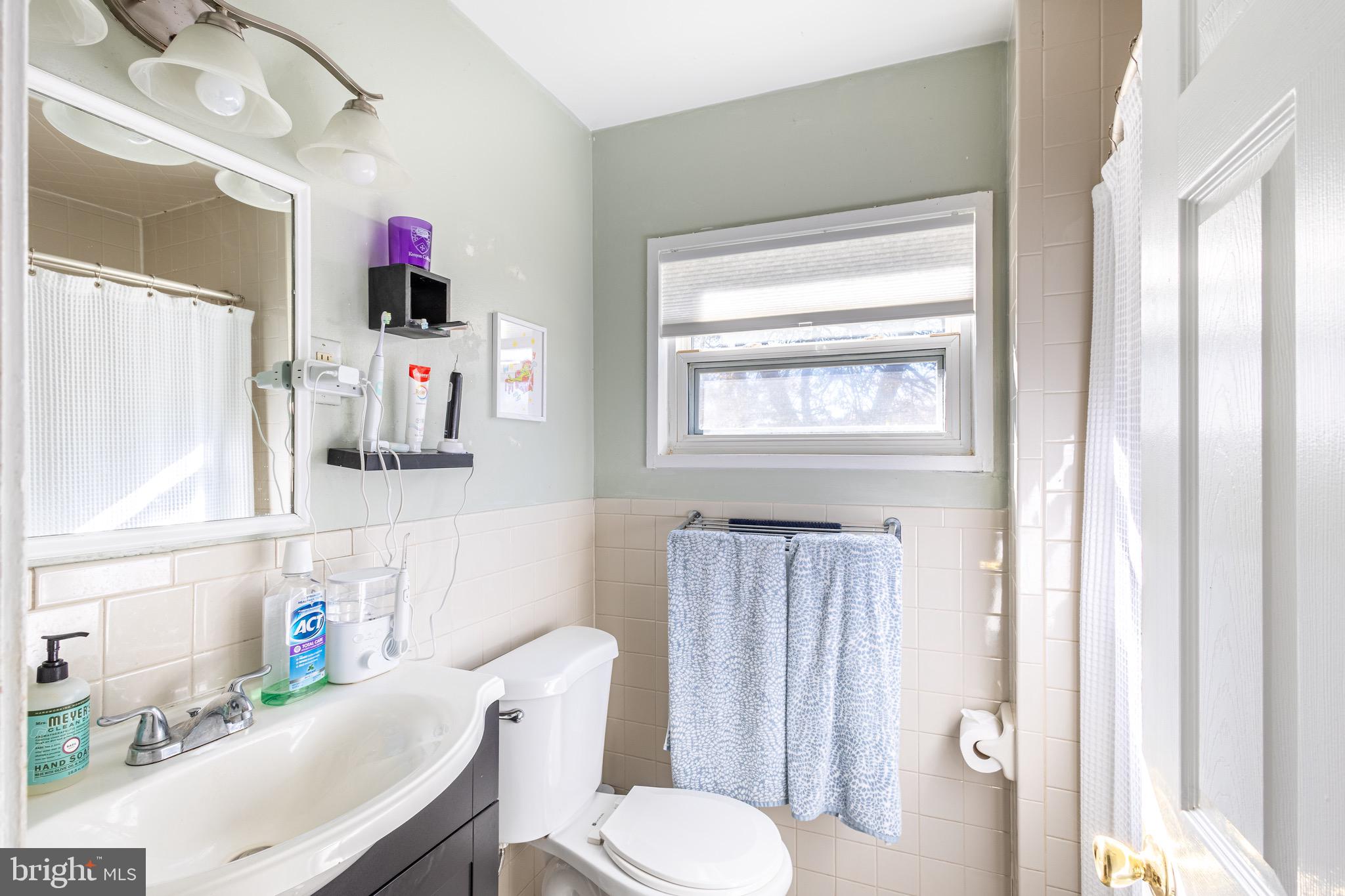 10611 Maple Street Fairfax, VA 22030 - Photo 16 of 20 a bathroom with a sink toilet vanity and window