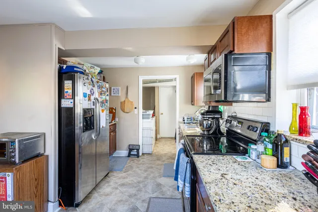 a kitchen with stainless steel appliances granite countertop a refrigerator and a sink