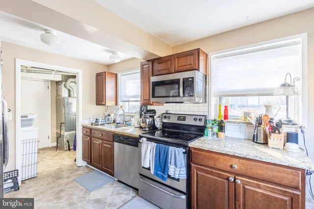 a kitchen with kitchen island granite countertop a sink stove and cabinets