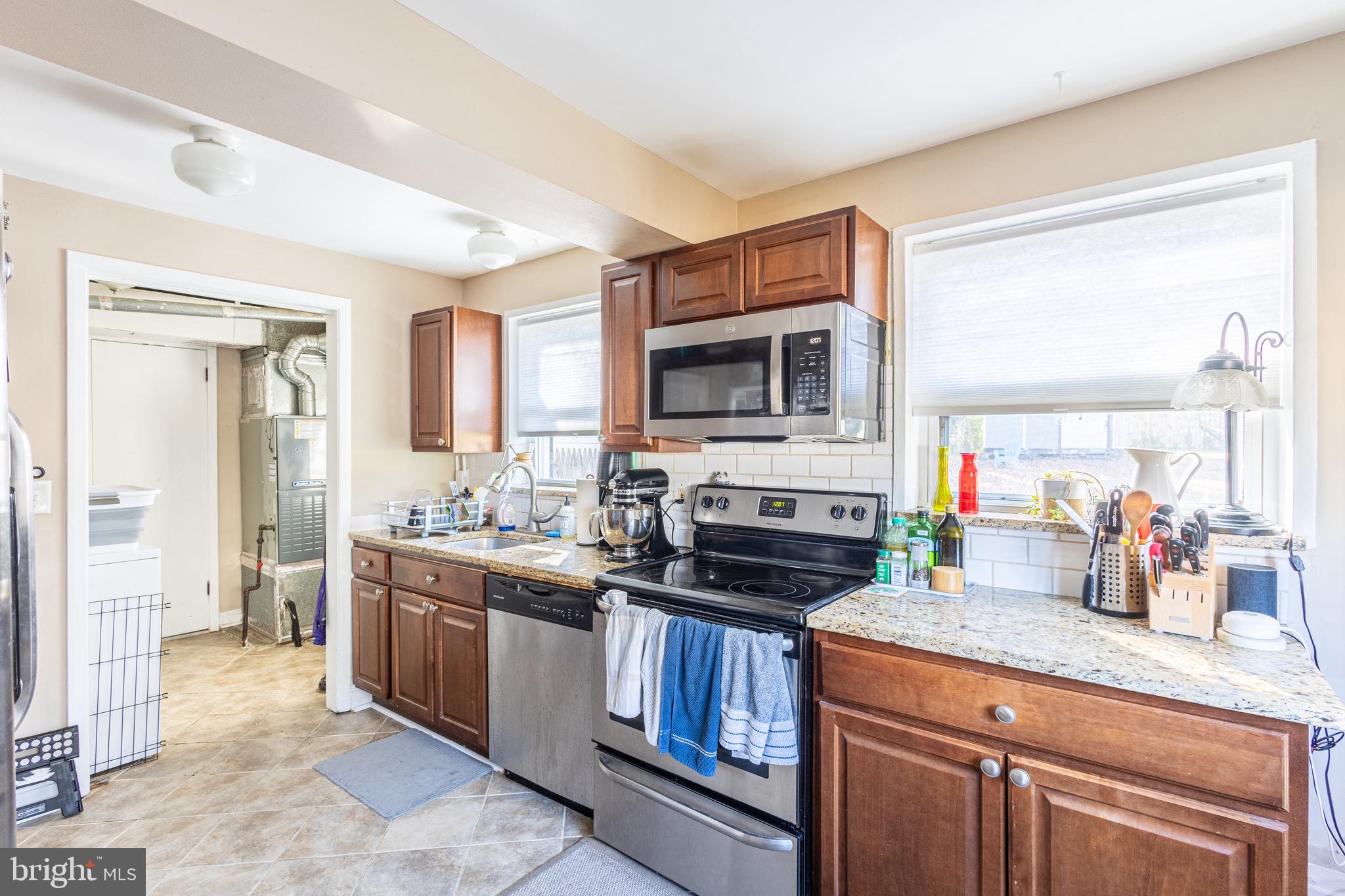 10611 Maple Street Fairfax, VA 22030 - Photo 7 of 20 a kitchen with kitchen island granite countertop a sink stove and cabinets