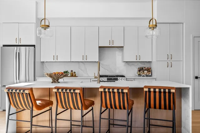 a kitchen with stainless steel appliances granite countertop a table chairs sink and cabinets
