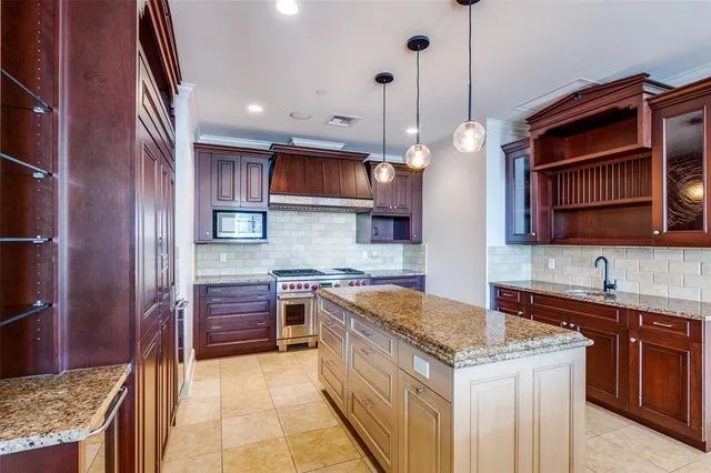 a kitchen with stainless steel appliances granite countertop a stove a sink and a microwave