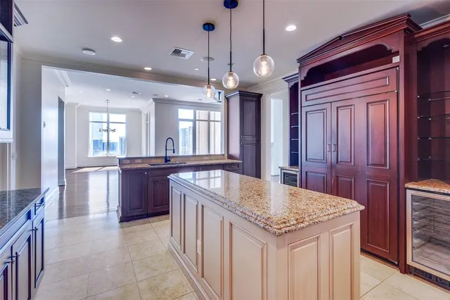 a kitchen with granite countertop cabinets a sink a island and windows in it