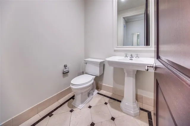 a bathroom with a toilet sink and mirror