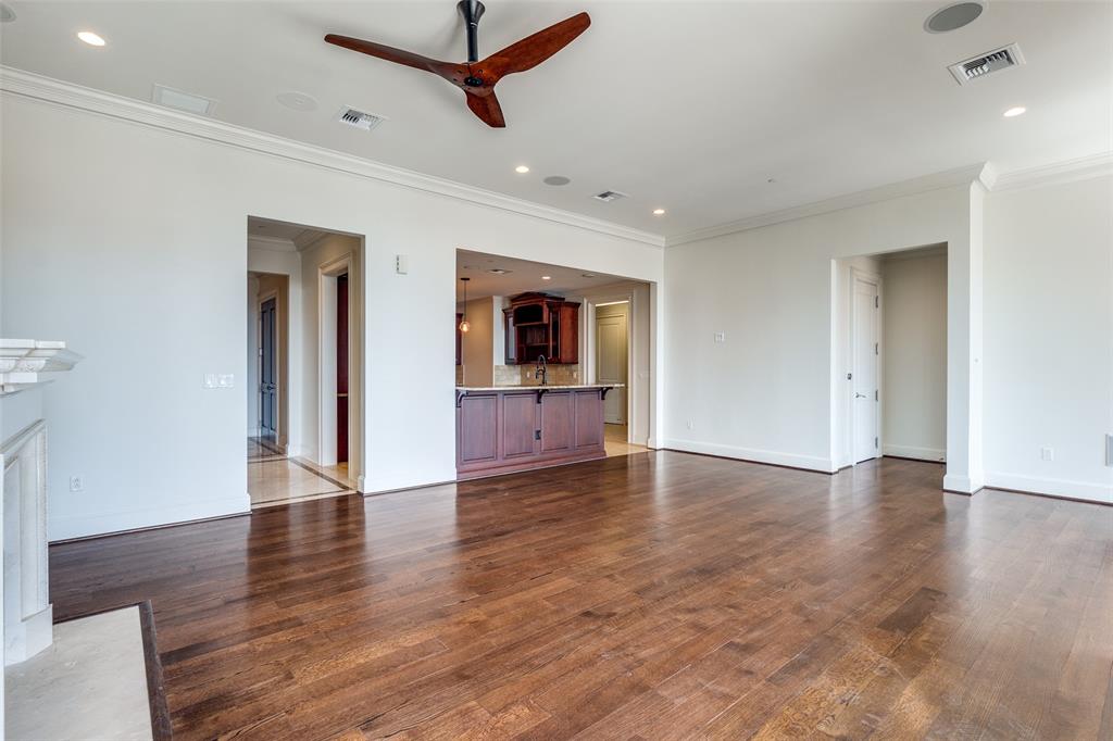 2555 North Pearl Street, Unit 2001 Dallas, TX 75201 - Photo 9 of 36 a view of an empty room with wooden floor and a ceiling fan