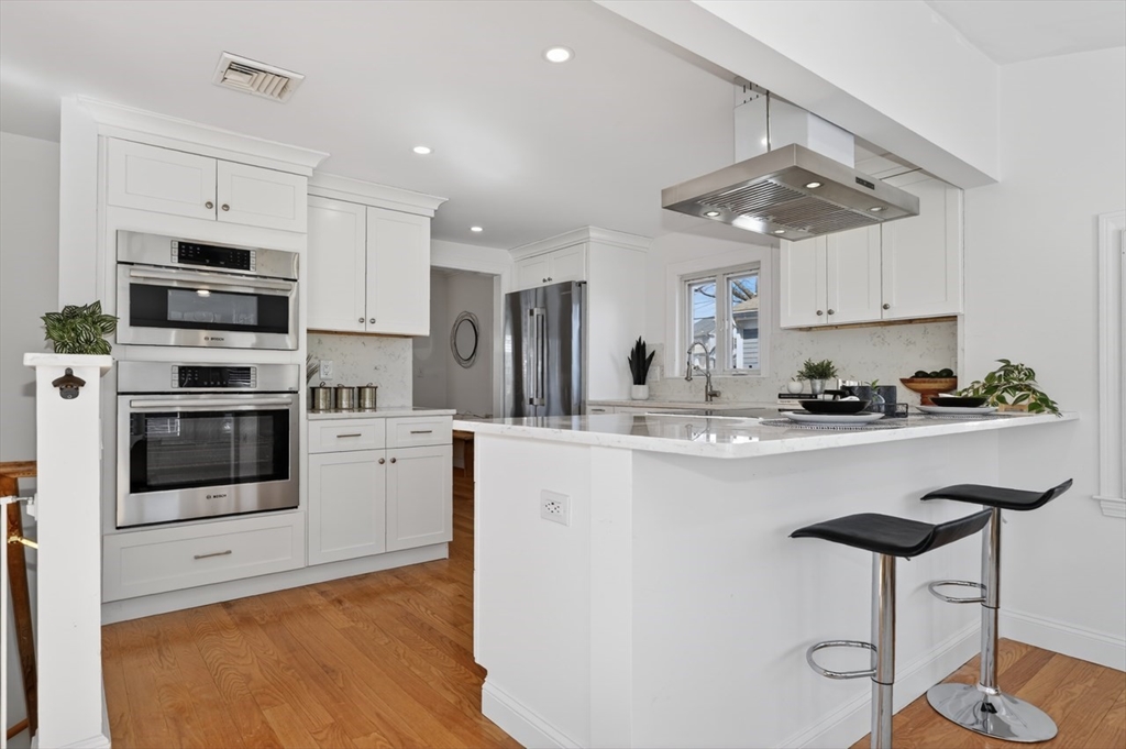 23 Stearns Road Belmont, MA 02478 - Photo 10 of 42 a kitchen with stainless steel appliances a stove a refrigerator and white cabinets