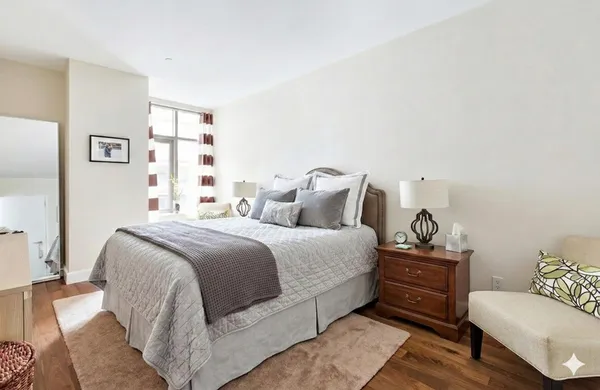 a living room with furniture wooden floor and a large window