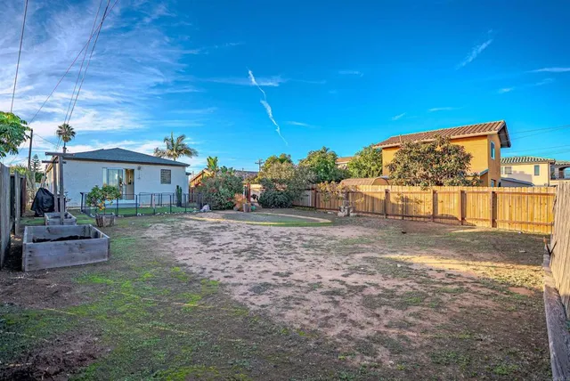 an aerial view of residential houses with outdoor space and parking
