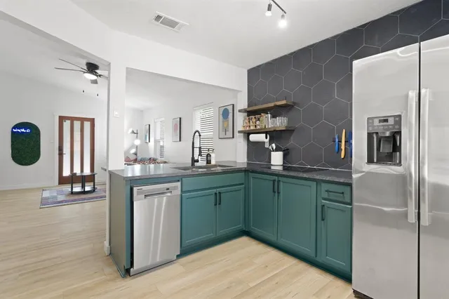 a kitchen with stainless steel appliances granite countertop a refrigerator and a sink