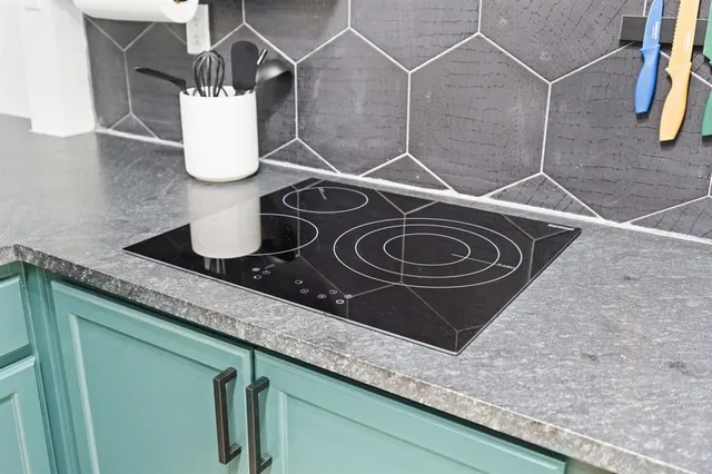 a kitchen with a sink and a stove with wooden floor