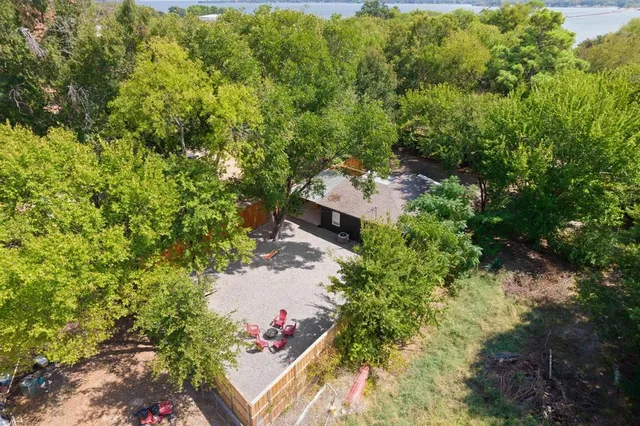 an aerial view of residential house with outdoor space and trees all around