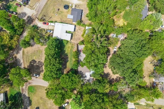 an aerial view of residential house with outdoor space and trees all around