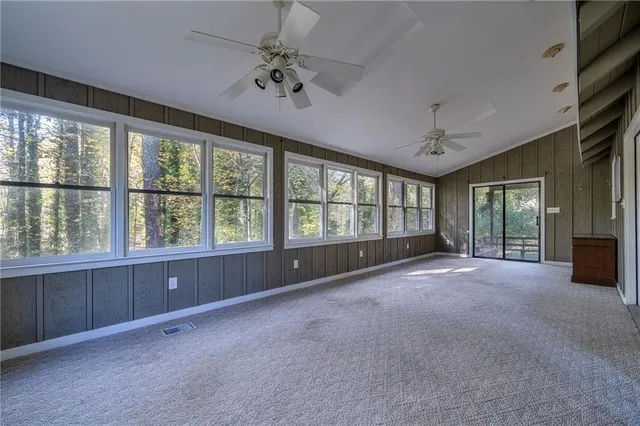 a view of an empty room with windows & cabinet